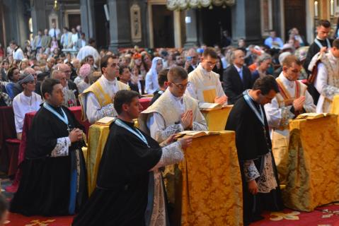 Les jeunes prêtres récitent en même temps que le Pontife les prières, assistés par un prêtre