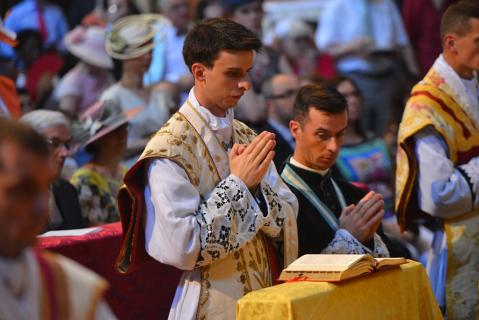 Les jeunes prêtres récitent en même temps que le Pontife les prières, assistés par un prêtre