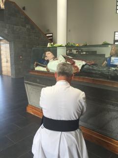 Le chanoine Moreau devant la châsse du Bienheureux Père Laval