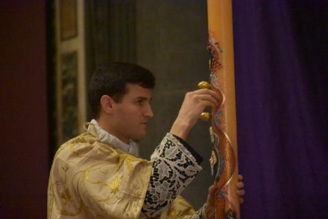 Le diacre plante, en forme de croix, dans le cierge pascal les cinq grains d&rsquo;encens bénits.