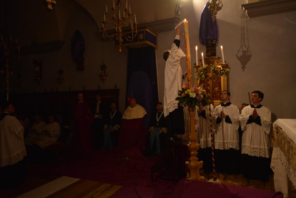 Un acolyte va allumer les cierges de la chapelle avec le feu du cierge pascal