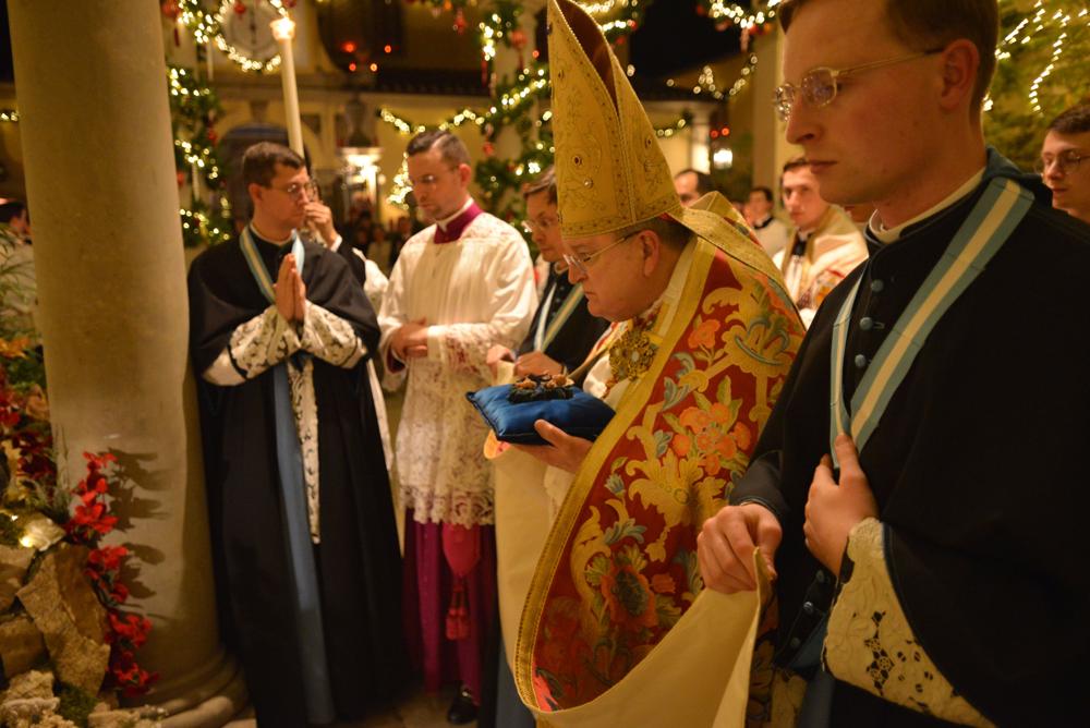 Le Cardinal porte l&rsquo;Enfant-Jésus qui sera déposé dans la Crèche